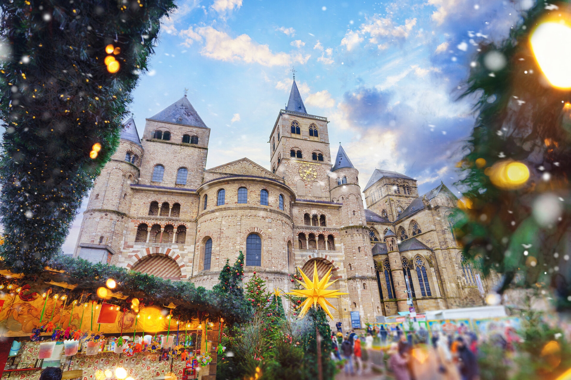 Festlich geschmückter Weihnachtsmarkt vor romanischem Dom