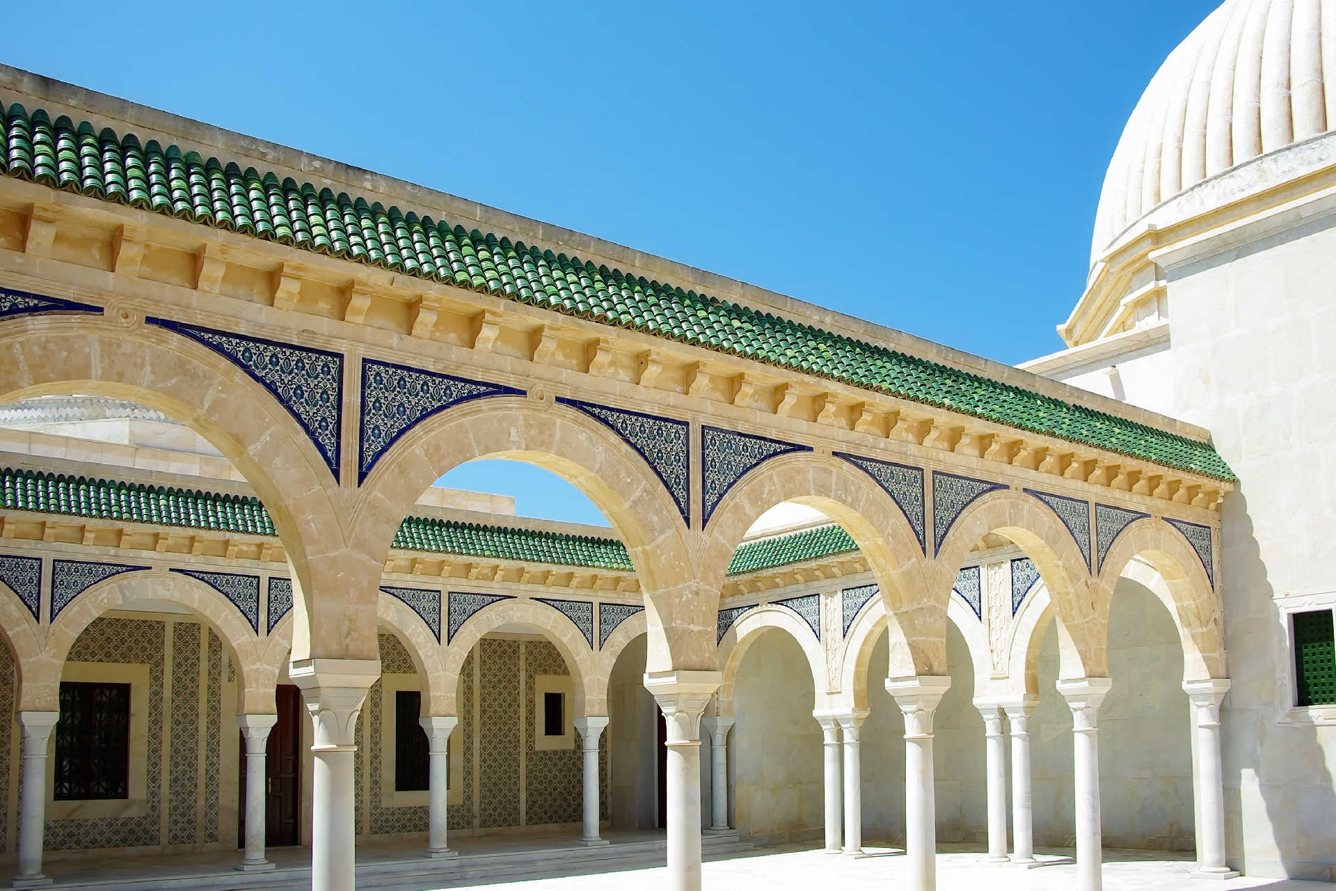 Innenhof mit Säulen und grünem Ziegeldach des Mausoleums in Monastir