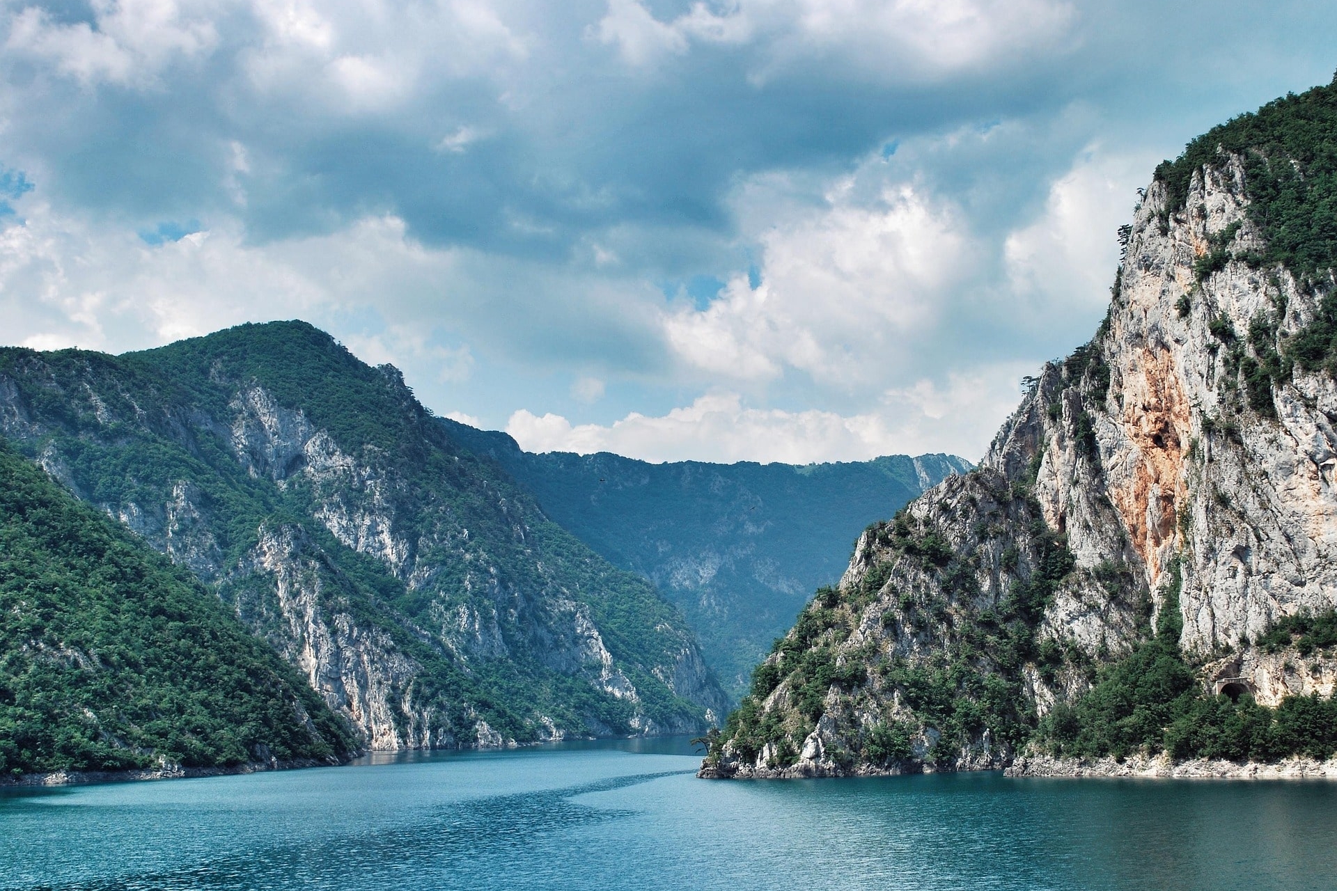 Tiefe Schlucht mit türkisfarbenem Fluss zwischen bewaldeten Felswänden