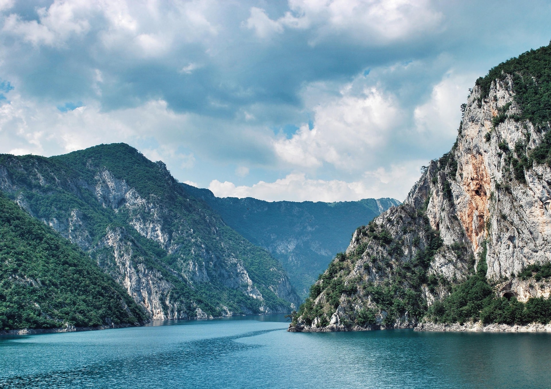 Tiefe Schlucht mit türkisfarbenem Fluss zwischen bewaldeten Felswänden